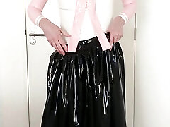 Putting on another long latex skirt over skirt, blouse, rubber maid stockings and transparent panties, latex layers